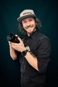 Porträt von Andreas Baumann, Hochzeitsfotograf aus Innsbruck, mit seiner Kamera in der Hand